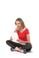 Naklejka premium Young modern woman sitting on floor using a tablet