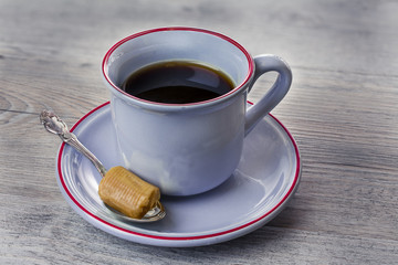 Blue cup of coffee with one toffee