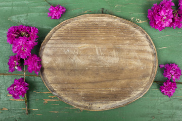 Oval plaque and pink flowers on a retro wooden planks