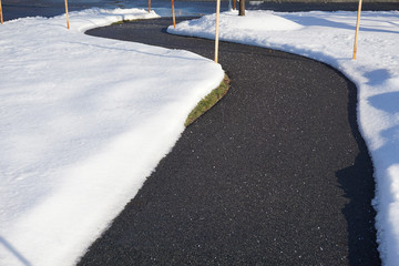 winding sidewalk after snow with snow removed