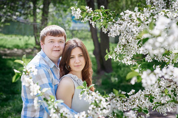 Fototapeta premium Young couple posing in blossoming spring garden