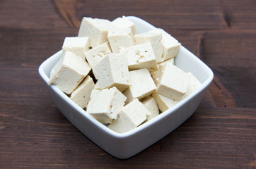 Cubes of tofu square bowl on wooden table