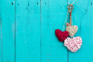 Skeleton key and rope hearts hanging on rustic door