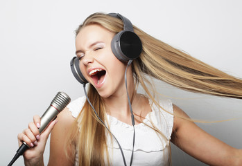 Beautiful young woman with microphone and headphones 