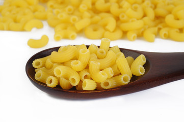 raw pasta macaroni in wooden spoon