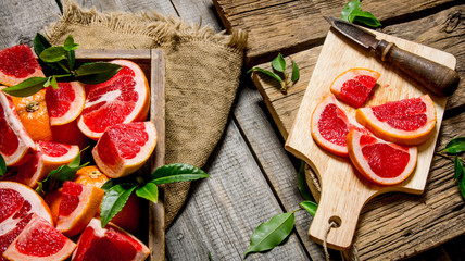 Sliced grapefruit on the Board with a full box and leaves.