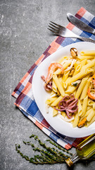 Pasta with seafood on a plate on the fabric. Top view