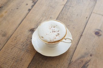 Hot cappuccino on wood background