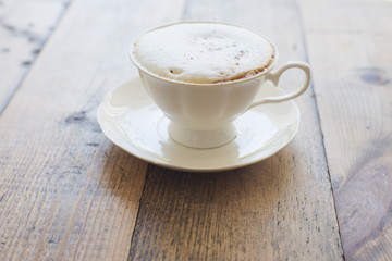 Hot cappuccino on wood background