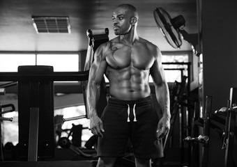 Fototapeta na wymiar Athlete muscular brutal bodybuilder emotional posing in the gym