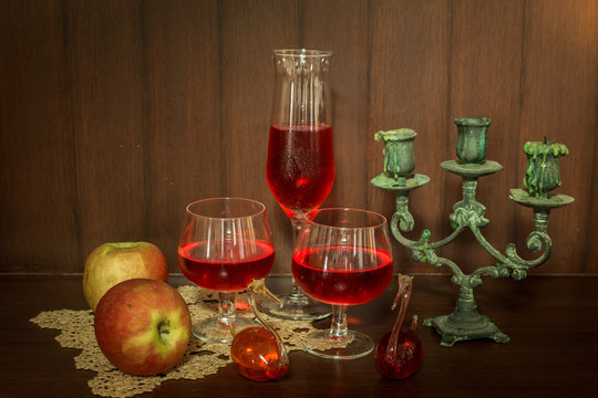 Still life image of red wine and fruits over wooden background