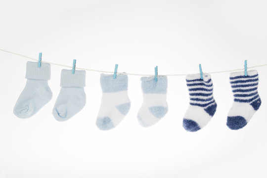 Blue and white baby socks on clothesline, isolated