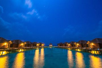 Fototapeta premium Over water bungalows with steps into amazing green lagoon 
