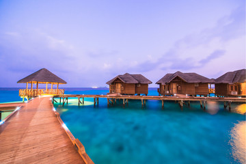 Fototapeta premium Over water bungalows with steps into amazing green lagoon 
