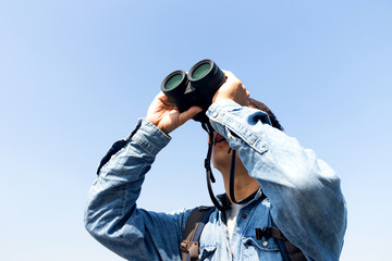 Young Man use of the binocular and looking up