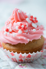 Veganer Cupcake mit Himbeerfrosting und Blütendekor