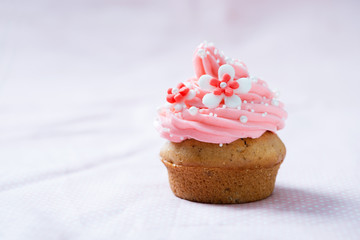 Veganer Cupcake mit Himbeerfrosting und Blütendekor