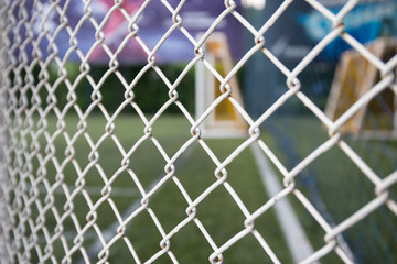white metal grate fence texture  and sport field background