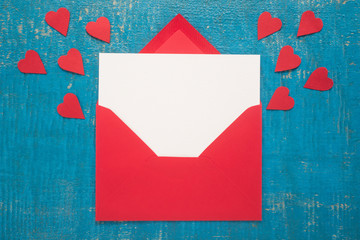 Red envelope with hearts on  wooden background 