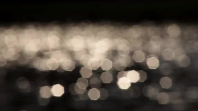 Fragrant sea of playing white specks on the dark background. Amazing vibrant beams out of focus. Hypnotic play of the light. Excellent abstract meditative and relax intro with blinking gleams.