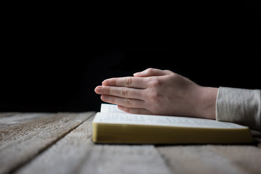 woman hands on bible. she is reading and praying over bible over