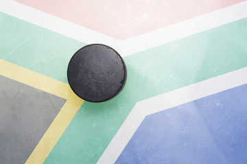 old hockey puck is on the ice with south africa flag