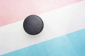 old hockey puck is on the ice with luxembourg flag