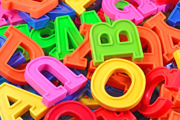 Heap of plastic colored alphabet letters close up