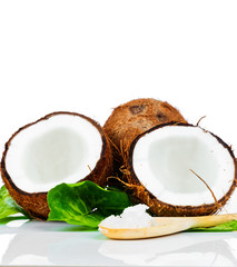 Coconuts with green leaves and a wooden spoon
