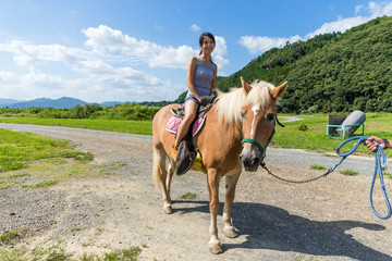 Asian Woman riding a horse