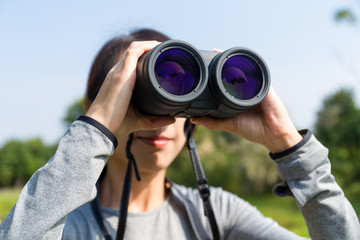 Woman use of the binocular in forest