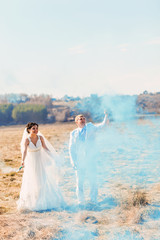 Wedding couple with blue smoke in the park