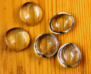 Five oval cabochons for crafts.On a wooden table.