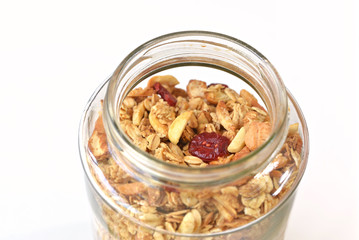 Granola with honey, oatmeal, cashew nut, almond, raisin and cranberry on white background