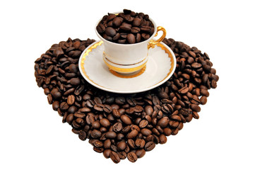 A cup of coffee on grains in the shape of a heart on a white bac