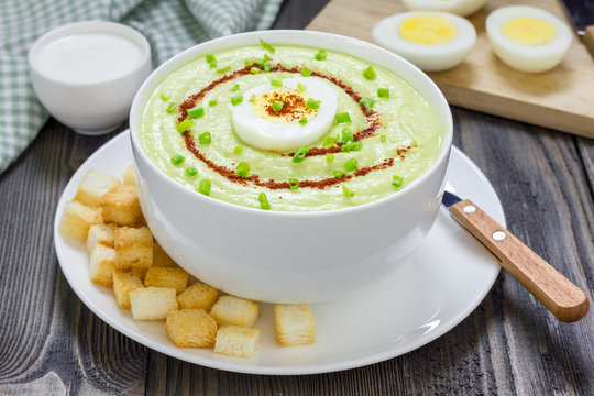 Cream soup with avocado, garnished with egg and croutons. Healthy eating.