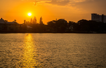 Fototapeta premium sunrise over river with gold reflection wave