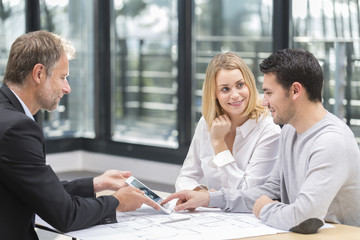 young couple meeting real estate agent for future house