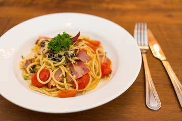 Spaghetti with bacon and dried chilli in white dish