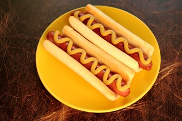 Hot dogs with mustard on yellow plate
