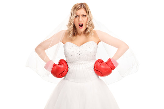 Angry bride in a wedding dress and boxing gloves