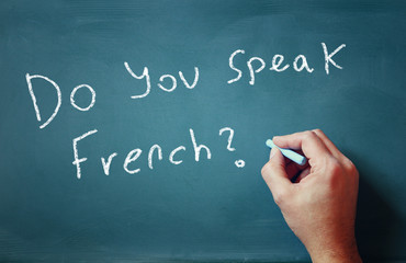 Fototapeta premium Man writes -Do you speak french- on a chalkboard 