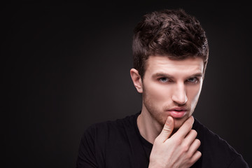 Stylish guy close up portrait on black background