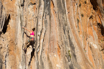 Young male climber hanging by a cliff