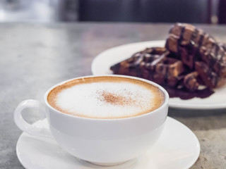 selective focus coffee  and blur chocolate waffle, cement background