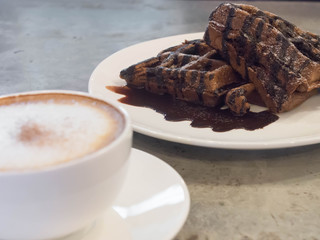 selective focus chocolate waffle and blur coffee, cement background