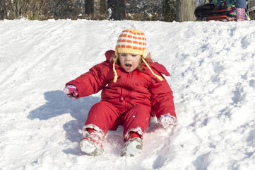 Fototapeta na wymiar Little girl playing outdoors in snow