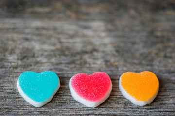 Naklejka na ściany i meble Colorful candy sweet hearts on wooden background.- Vintage filte