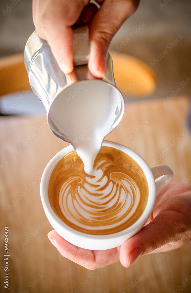 Wall mural Cup of coffee latte in coffee shop.