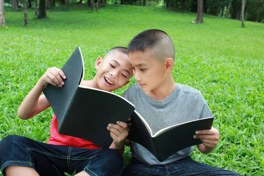 Two Boys Reading In The Park.